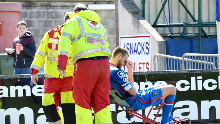 Inverness defender Gary Warren leaves the pitch after suffering a leg injury