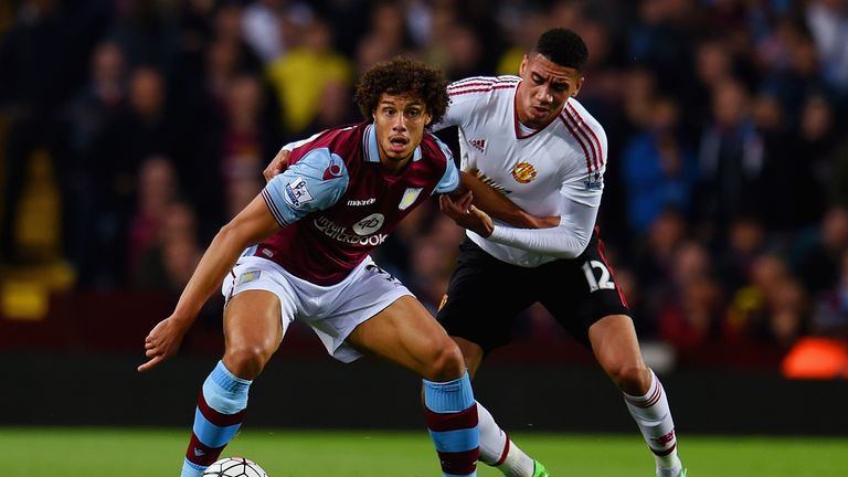BIRMINGHAM, ENGLAND - AUGUST 14:  Rudy Gestede of Aston Villa holds off Chris Smalling of Manchester United during the Barclays Premier League match betwee