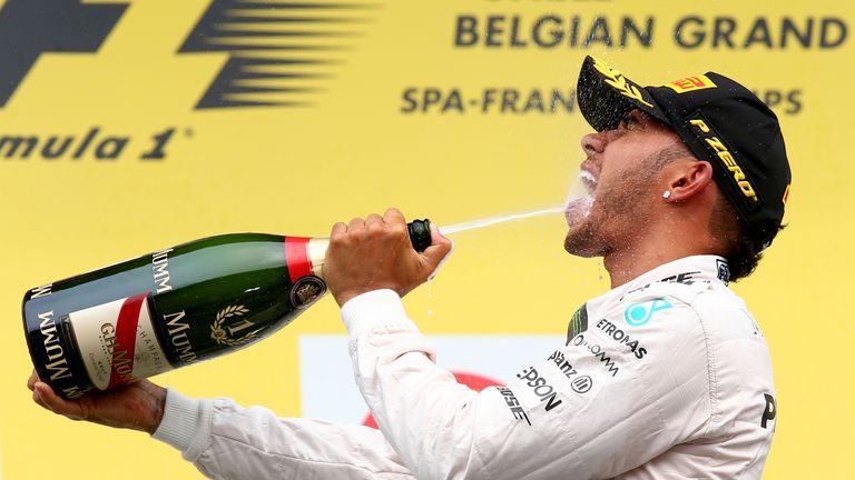 Lewis Hamilton celebrates on the podium after winning at Spa