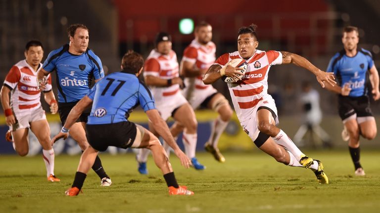 Japan's Hendrik Tui (R) runs with the ball during a match against Uruguay at Prince Chichibu Memorial Rugby Ground in Tokyo