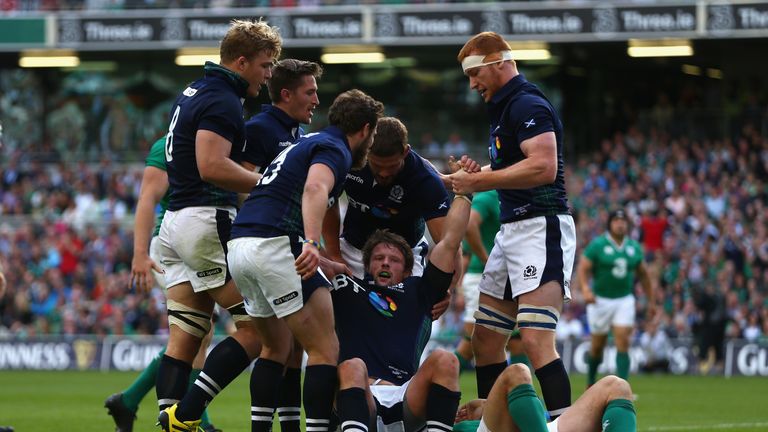 DUBLIN, IRELAND - AUGUST 15:  Peter Horne of Scotland is helped to his feet by team mates after scoring his sides third try during the International match 