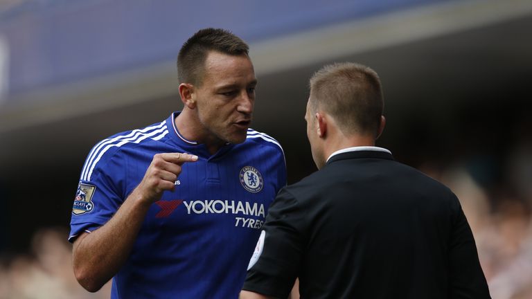 Chelsea's defender John Terry (left) talks with assistant referee Harry Lennard (right).