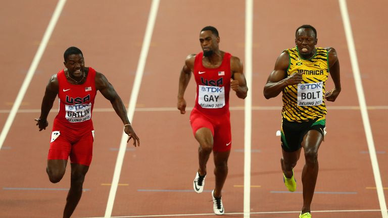 Usain Bolt of Jamaica (R) crosses the finish line