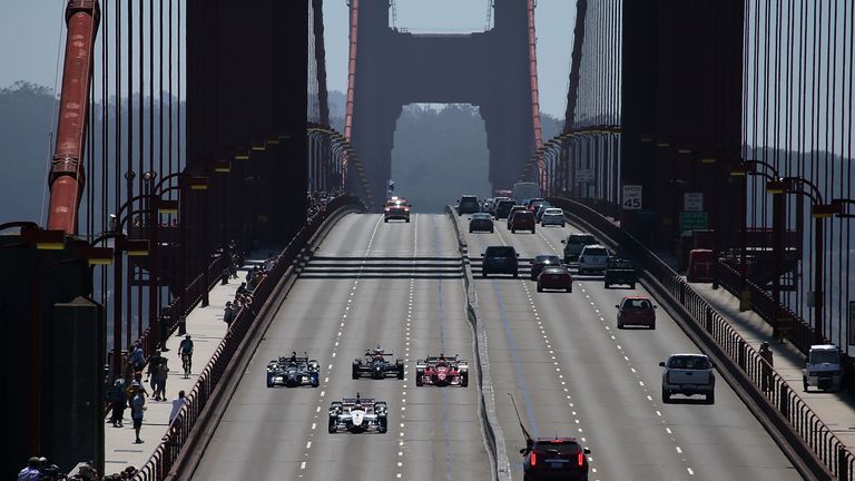 Indy cars, lead by Marco Andretti in the #25 car, drive across the Golden Gate Bridge
