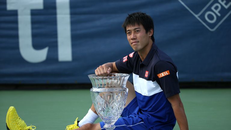 Kei Nishikori of Japan celebrates with the trophy after beating John Isner in Washington  