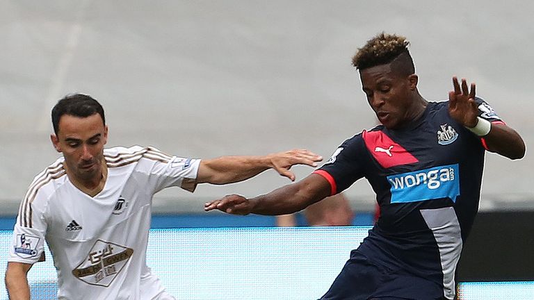 Swansea City midfielder Leon Britton (L) vies for the ball with Newcastle United's Massadio Haidara 