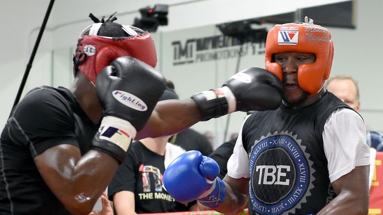 Boxer Floyd Mayweather Jr. (R) spars with boxer Don Moore during a media workout 