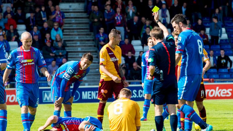 Motherwell's Stephen Pearson (8) is shown a yellow card after his challenge on the injured Gary Warren 
