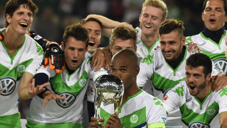 Wolfsburg's Brazilian defender Naldo (C) kisses the trophy and celebrates with Wolfsburg's players after winning the German Super Cup 