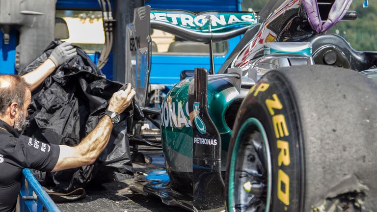 Mercedes mechanics cover up the blown tyre on Nico Rosberg's W06