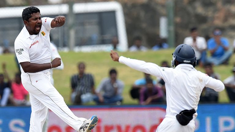 Sri Lankan cricketer Rangana Herath (L) and teammate Kaushal Silva (R) celebrate during the fourth day of the opening Test