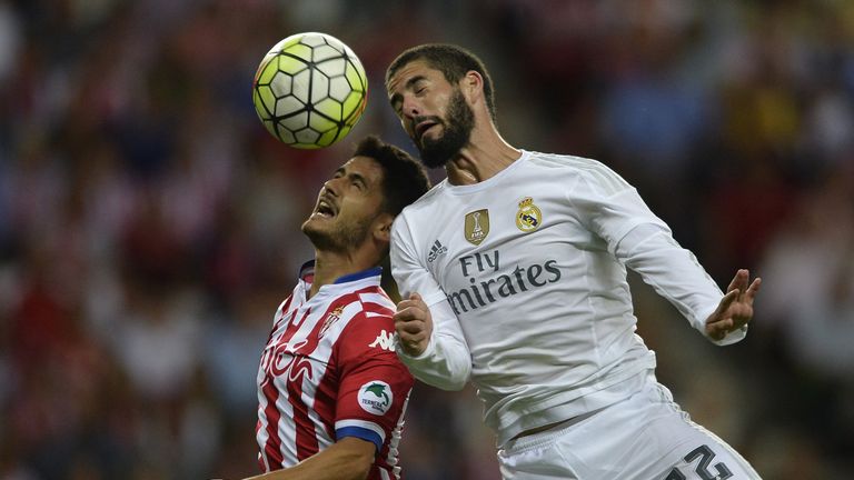 Sporting Gijon's midfielder Nacho Cases (L) vies with Real Madrid's midfielder Isco