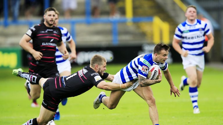 Halifax's Ben Johnston tackled by Rhys Hanbury