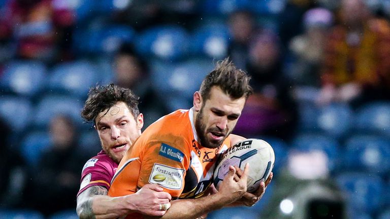 Castleford's Scott Moore is tackled by Huddersfield's Scott Grix.