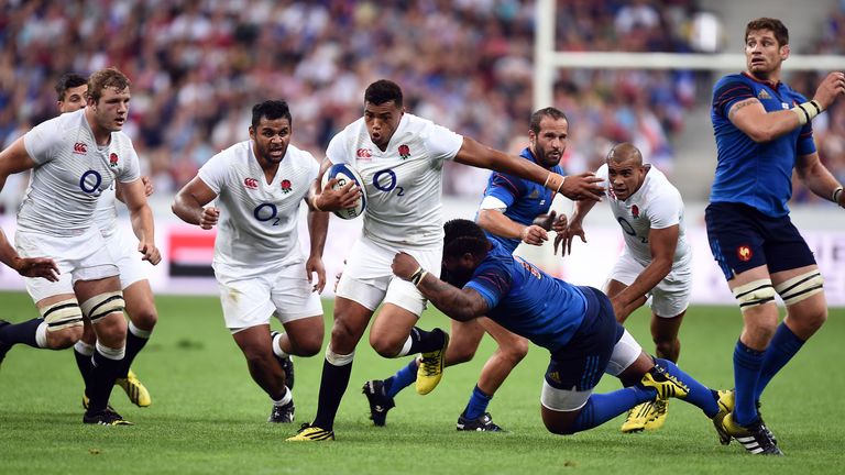 England's Luther Burrell powers through the France defence despite the best efforts of Franceis Mathieu Bastareaud