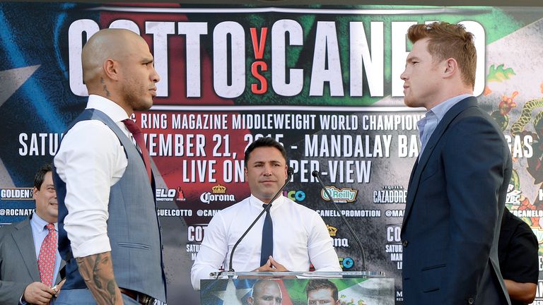 Oscar De La Hoya looks on as Miguel Cotto and Saul Alvarez square off. 