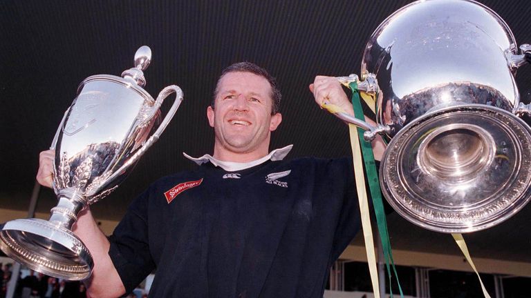 Sean Fitzpatrick holds aloft the Bledisloe Cup (r) and the Tri Nations trophy after defeating the Wallabies 