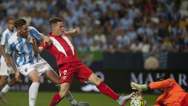 Malaga's defender Raul Albentosa (L) and Malaga's Cameroonian goalkeeper Carlos Kameni (R) vies with Sevilla's French forward Kevin Gameiro