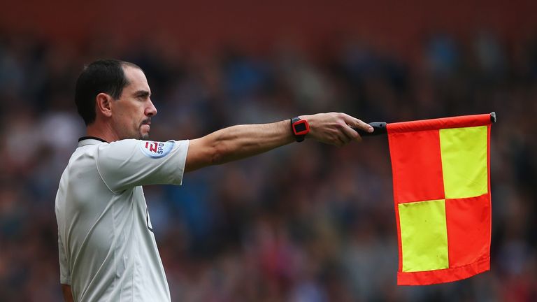 Assistant referee Stephen Child signals for offside