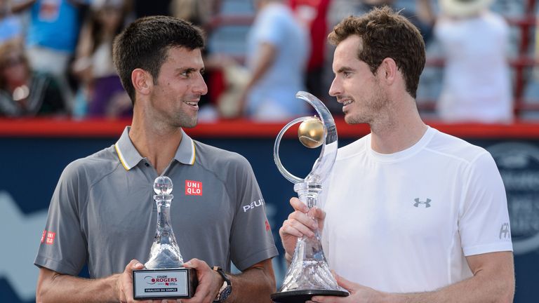 Novak Djokovic and Andy Murray looks at one another as they hold their trophies at the Montreal Masters
