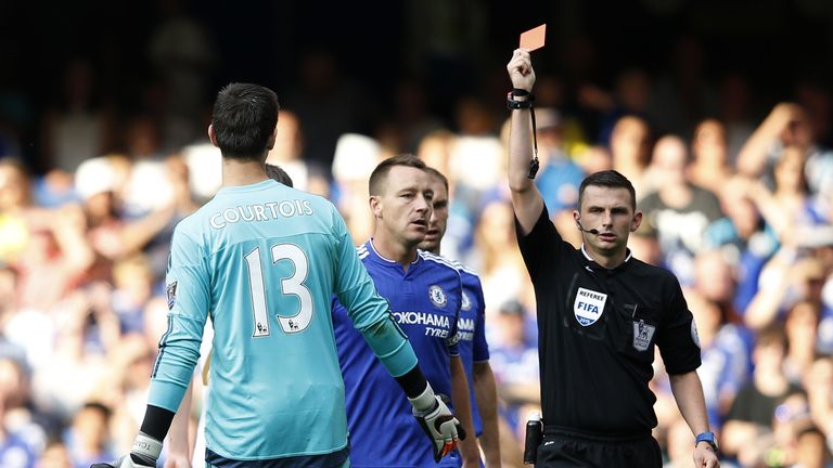 Referee Michael Oliver (R) shows the red card to send off Chelsea's Thibaut Courtois (L)