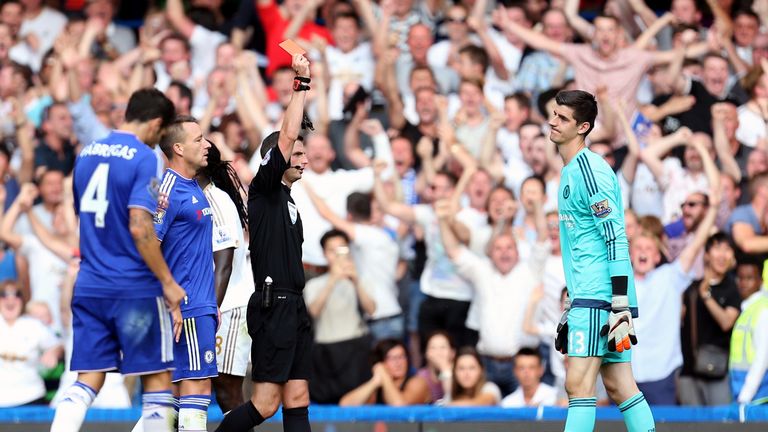 Chelsea goalkeeper Thibaut Courtois is shown a red card