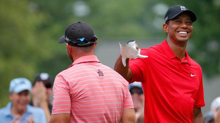 Tiger Woods congratulates Scott Brown after his hole-in-one at the third