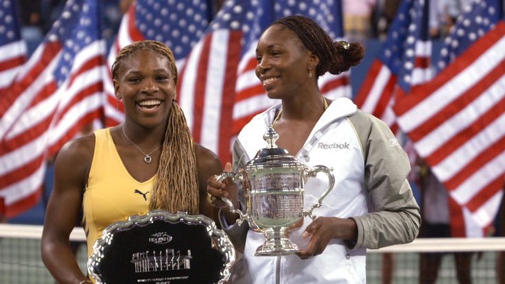 Venus Williams holds her trophy with her sister Serena Williams after the women's final match of the US Open
