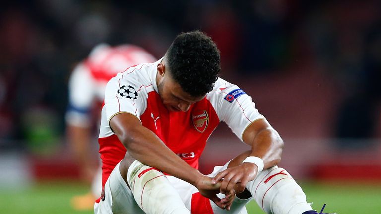 Alex Oxlade-Chamberlain sits on the turf after Arsenal's home defeat to Olympiakos
