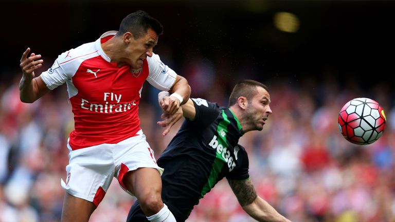 Alexis Sanchez of Arsenal wins a header from Phil Bardsley of Stoke City