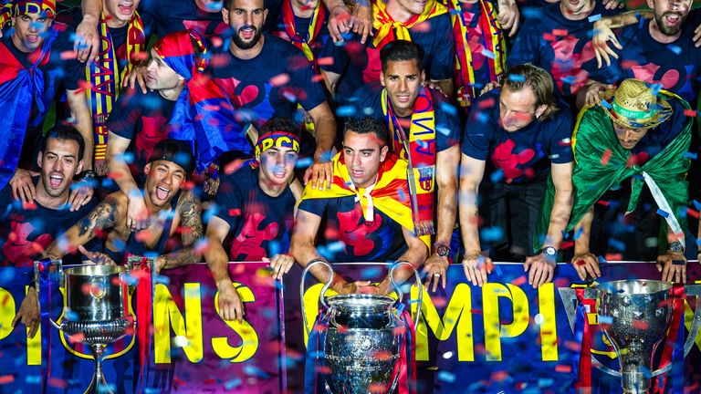 Barcelona players celebrate with La Liga, Copa del Rey and Champions League trophies 