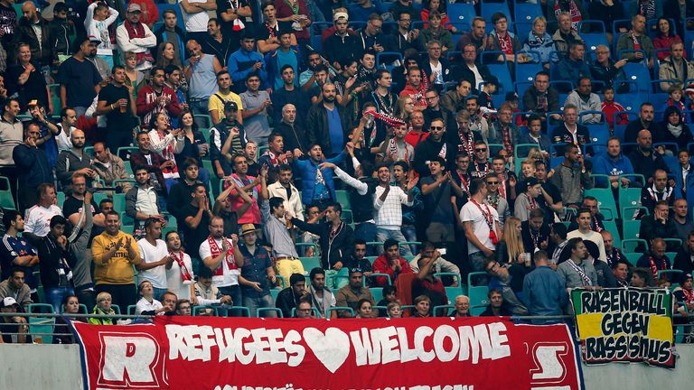 Invited refugees celebrate with fans of Leipzig during the Second Bundesliga match between RB Leipzig and SC Paderborn