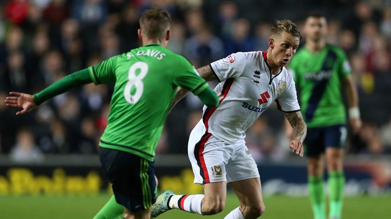 Milton Keynes Dons' Carl Baker (right) and Southampton's Steven Davis battle for the ball during the Capital One Cup, third round match at Stadium:MK
