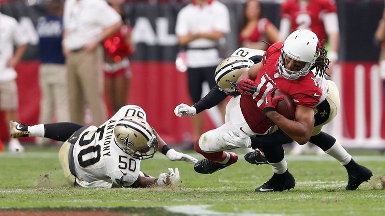 GLENDALE, AZ - SEPTEMBER 13: Wide receiver Larry Fitzgerald #11 of the Arizona Cardinals is hit by inside linebacker Stephone Anthony #50 of the New Orlean