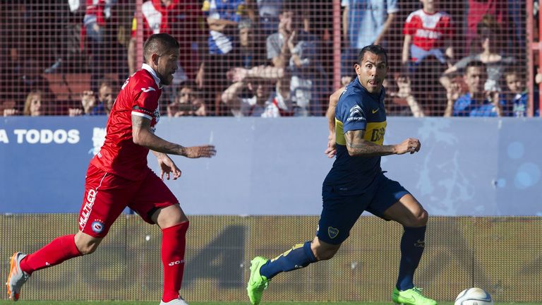 Boca Juniors' forward Carlos Tevez (R) drives the ball past Argentinos Juniors' defender Miguel Torren