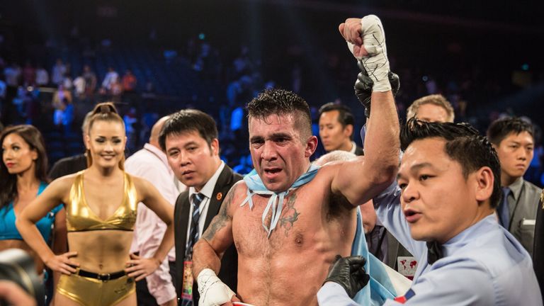 Argentina's Cesar Cuenca (C) holds his belt