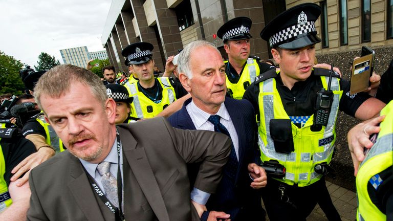 Former Rangers chief executive Charles Green (middle) is led away from Glasgow Sheriff Court after being granted bail after his court appearance