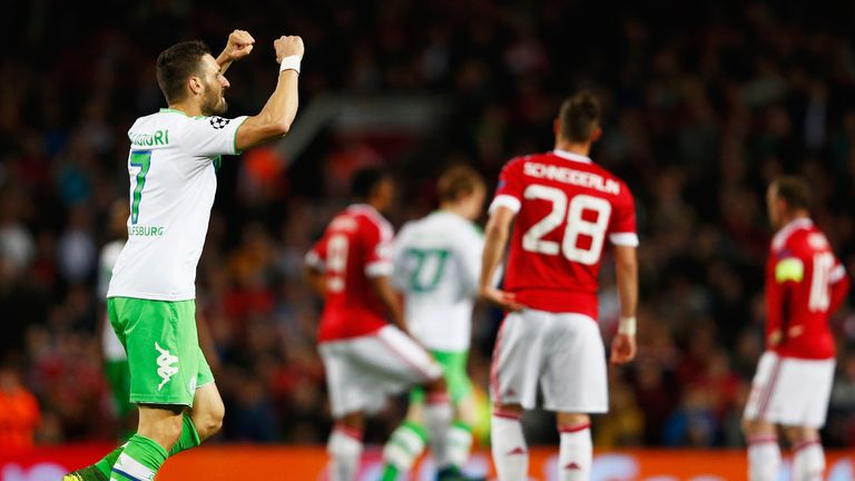 MANCHESTER, ENGLAND - SEPTEMBER 30:  Manchester United players look dejected as Daniel Caligiuri of VfL Wolfsburg celebrates as he scores their first goal 