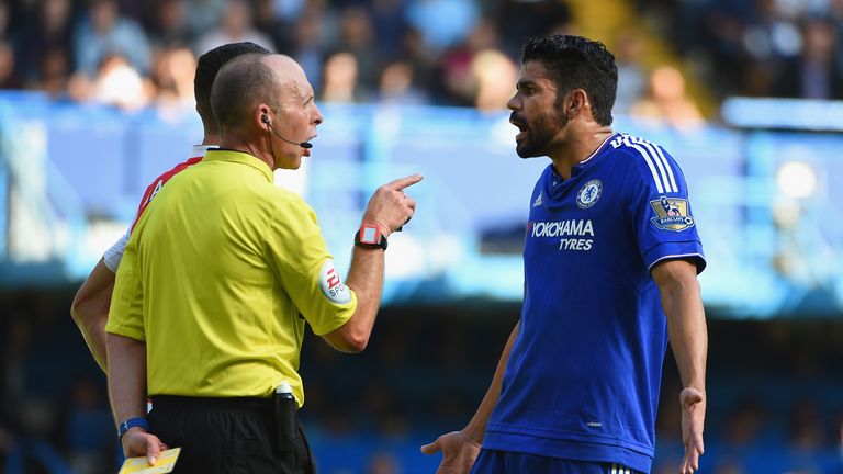Diego Costa of Chelsea is shown a yellow card by referee Mike Dean during the match against Arsenal