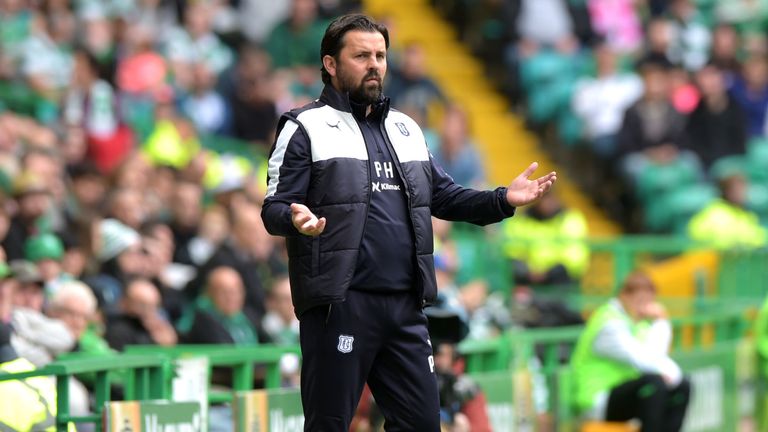 Dundee manager Paul Hartley stands dejected the dugout