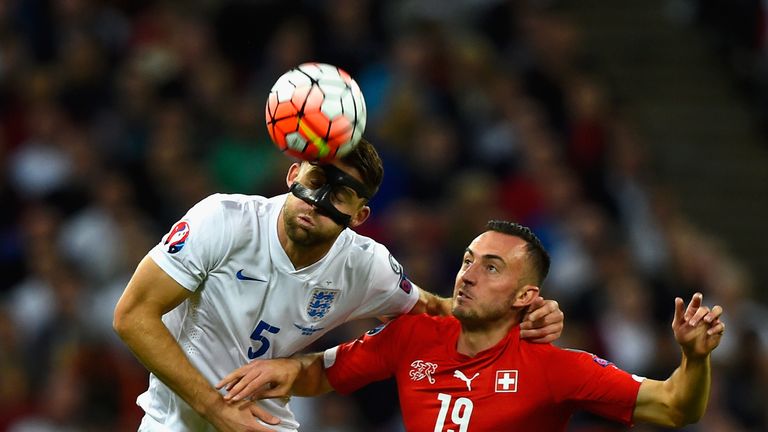Gary Cahill of England heads the ball under pressure from Josip Drmic of Switzerland during the UEFA European Qualifier at Wembley Stadium