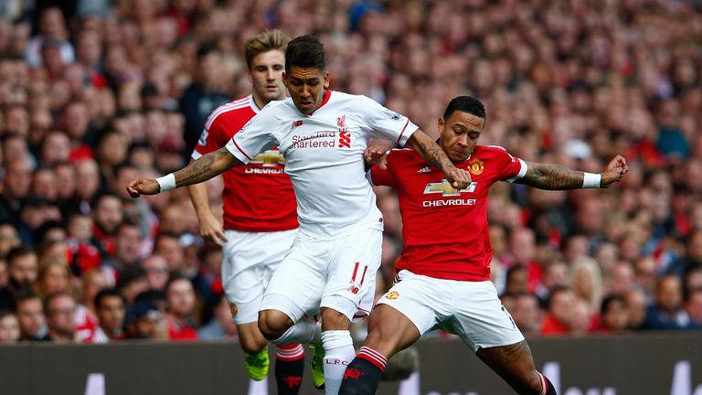 Roberto Firmino of Liverpool is challenged by Memphis Depay