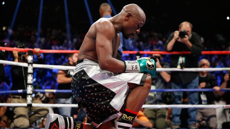Floyd Mayweather Jr. kneels on the mat after winning his WBC/WBA welterweight title fight against Andre Berto at MGM Grand G