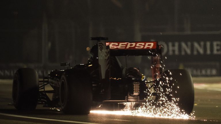 Sparks fly behind the car of Max Verstappen