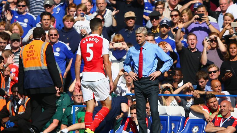 Gabriel of Arsenal walks off the pitch in front of Head coach Arsene Wenger as he is shown a red card during the Barclays P