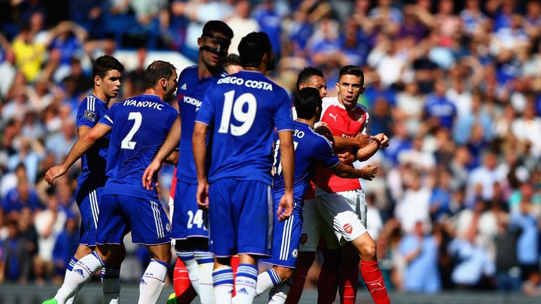 Gabriel is blocked by Chelsea players as he tries to walk toward Diego Costa