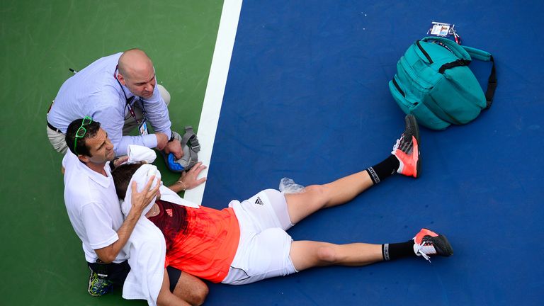  Jack Sock of the United States receives assistance from trainer Hugo Gravil for heat exhaustion during their Men's Singles Se