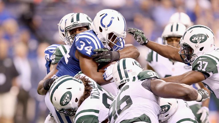 Josh Robinson of the Colts is tackled by a host of Jets at Lucas Oil Stadium