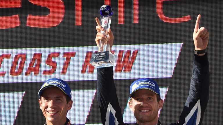 Sebastien Ogier (R) and his co-driver Julien Ingrassia (L) celebrate after winning their third World Rally Championship 