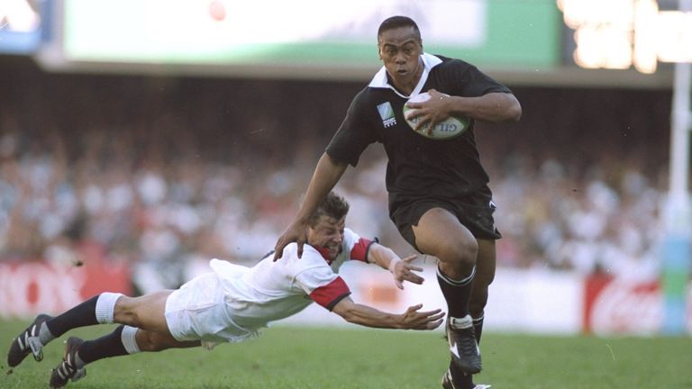 Jonah Lomu of New Zealand evades the tackle of Rob Andrew of England during the 1995 Rugby World Cup semi-final